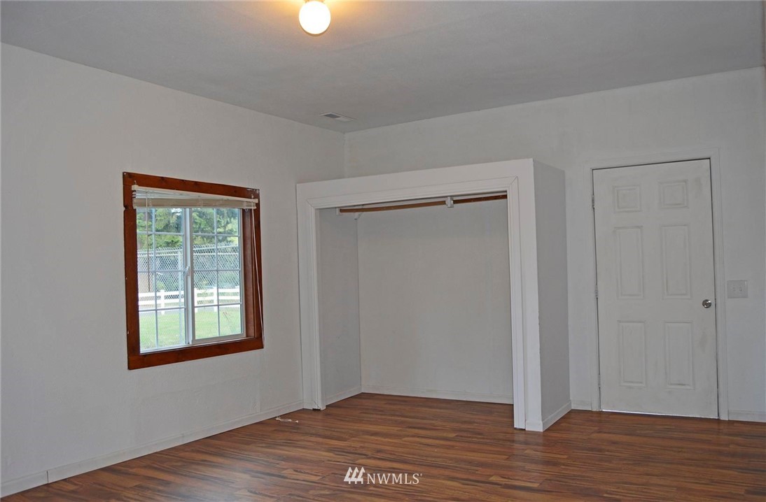 19215 Loganberry Street Southwest Rochester, WA 98579 - Photo 20 of 38 a view of an empty room with wooden floor and a window