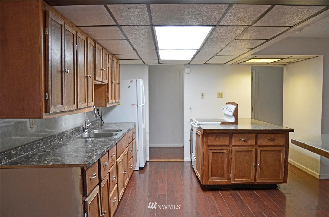 19215 Loganberry Street Southwest Rochester, WA 98579 - Photo 3 of 38 a kitchen with granite countertop a sink a counter space and wooden floor