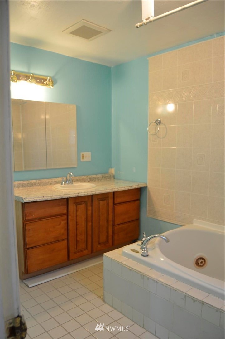 19215 Loganberry Street Southwest Rochester, WA 98579 - Photo 23 of 38 a bathroom with a tub sink and mirror