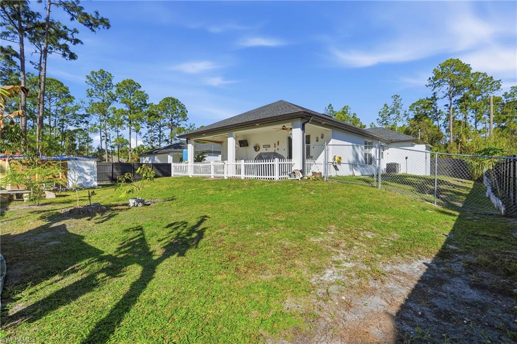 3409 64th Street West Lehigh Acres, FL 33971 - Photo 11 of 44 a view of a house with a big yard and potted plants