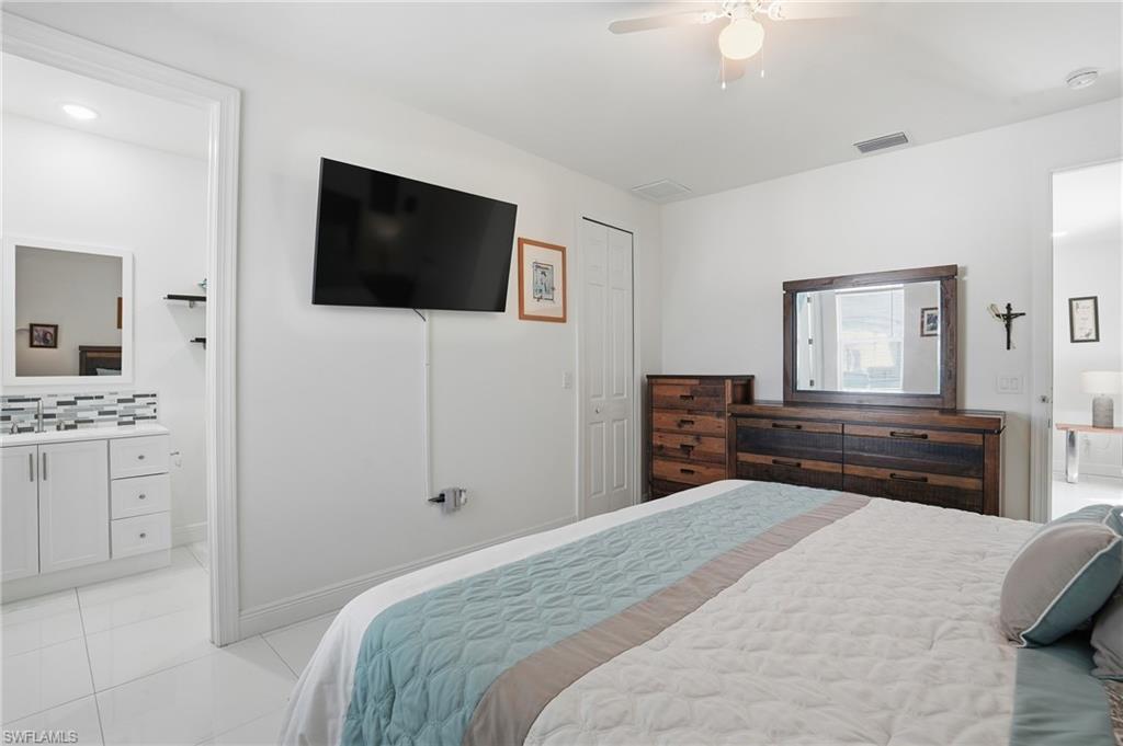 3409 64th Street West Lehigh Acres, FL 33971 - Photo 25 of 44 a bedroom with a bed and a flat screen tv