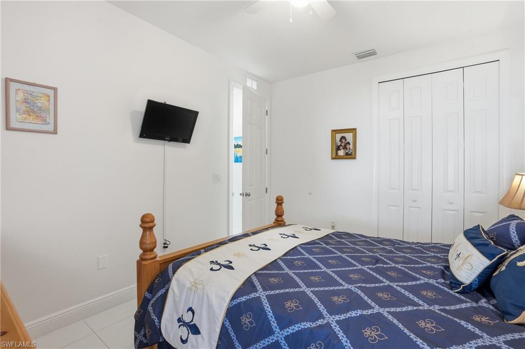 3409 64th Street West Lehigh Acres, FL 33971 - Photo 27 of 44 a bedroom with a bed and a flat screen tv