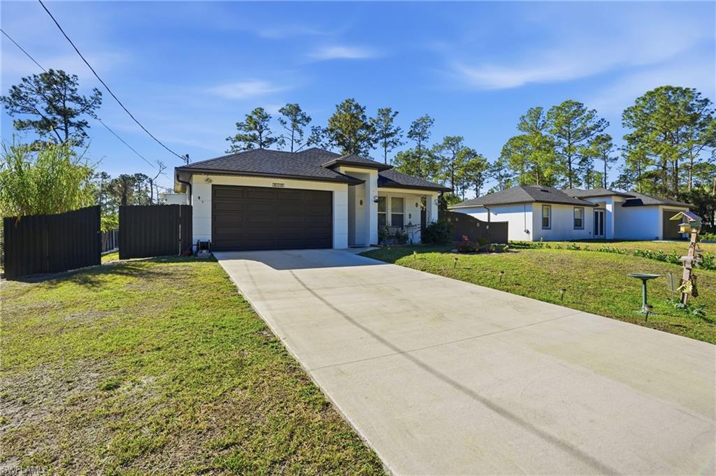 3409 64th Street West Lehigh Acres, FL 33971 - Photo 40 of 44 a front view of a house with a garden and yard