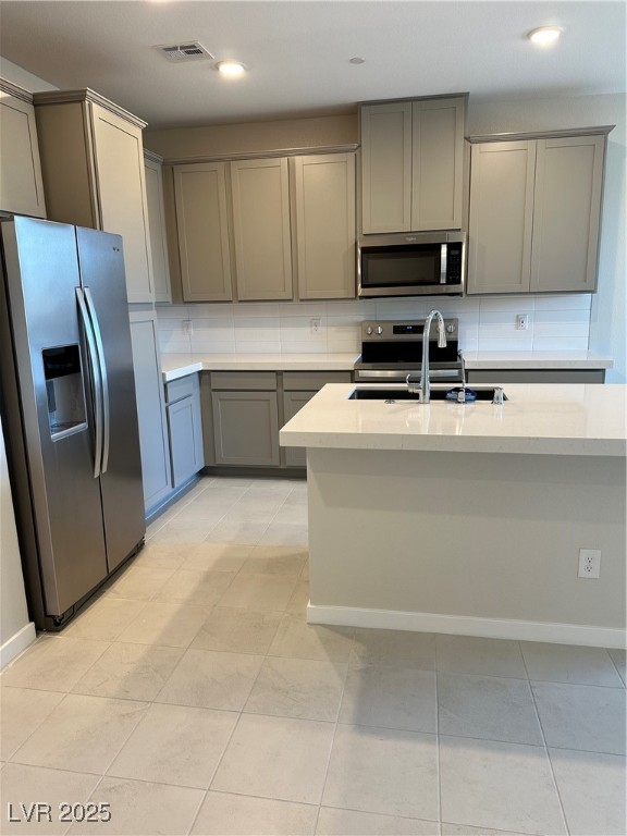 860 Angwin Lane Henderson, NV 89011 - Photo 2 of 9 Kitchen featuring gray cabinetry, fridge, decorative backsplash, range, and light stone counters