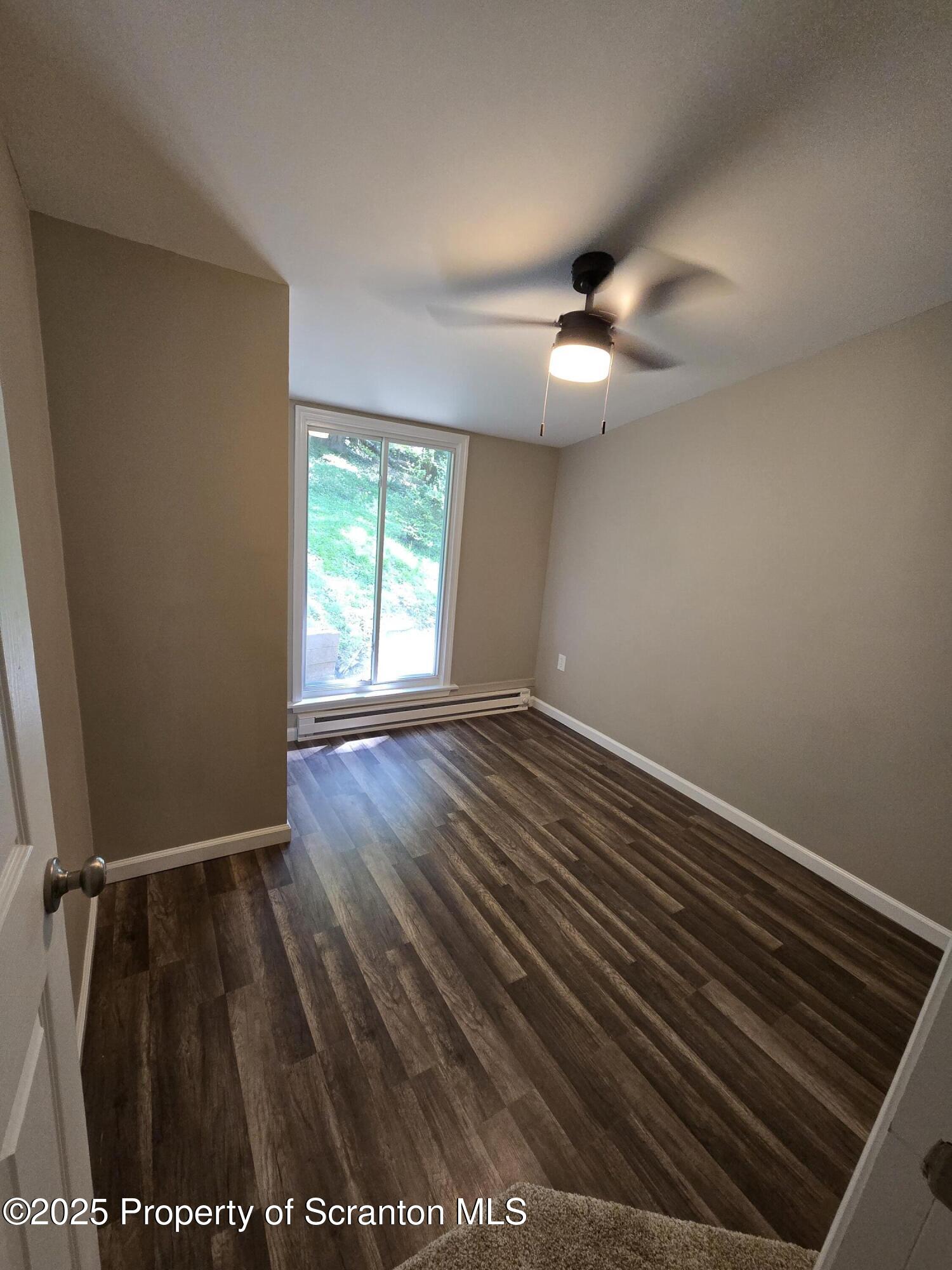 134 Chestnut Street Factoryville, PA 18419 - Photo 21 of 33 an empty room with wooden floor fan and windows