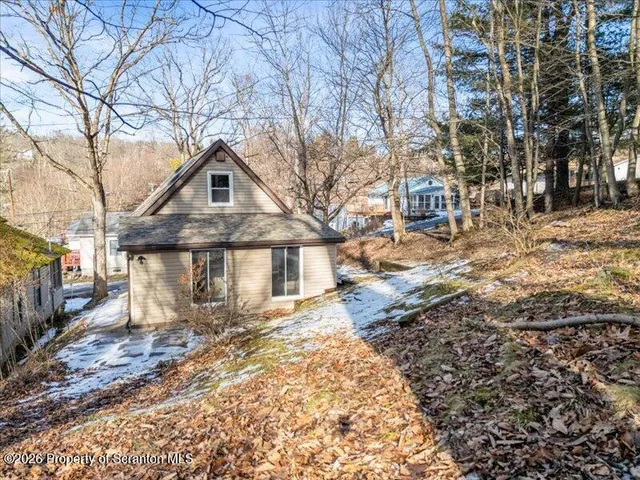 a front view of a house with a yard covered in snow