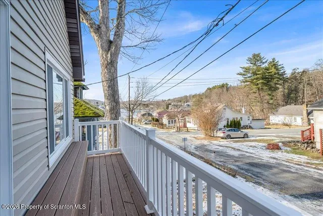a view of a balcony with wooden floor and fence and a potted plant