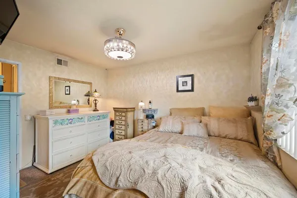 a view of a white house with a yard and potted plants