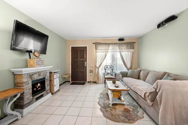 a living room with furniture a flat screen tv and a fireplace