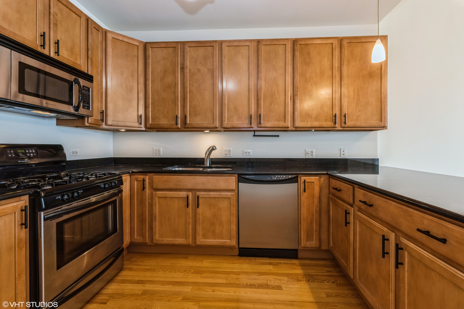 2510 West Irving Park Road, Unit 402 Chicago, IL 60618 - Photo 5 of 13 a kitchen with stainless steel appliances granite countertop a stove a sink and a microwave
