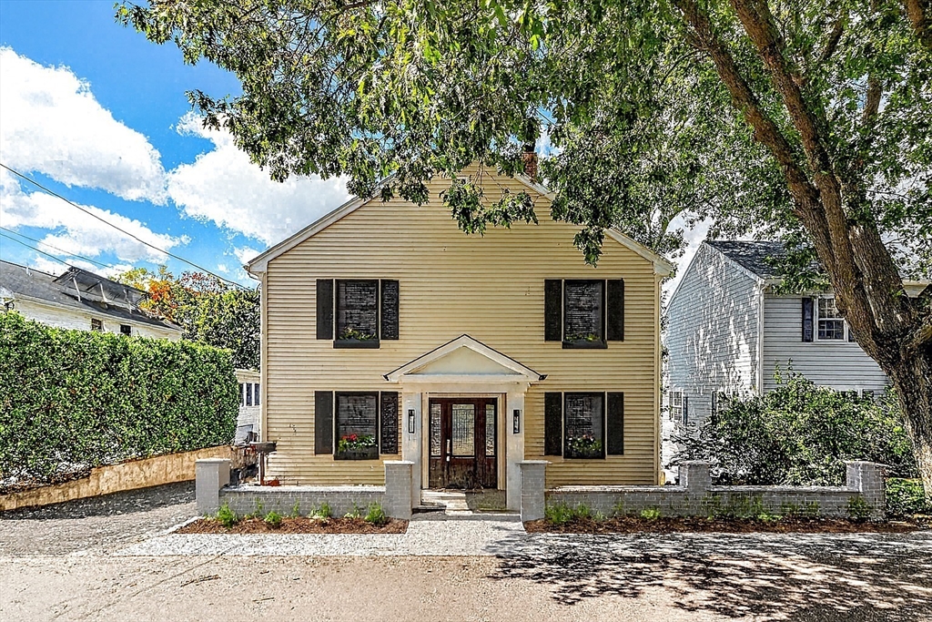 a view of a brick house with a large windows and large tree