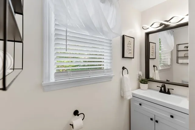 a bedroom with a bed a chair and next to a window
