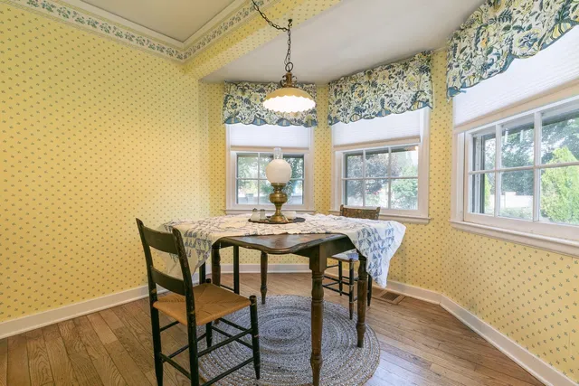 a dining room with furniture a chandelier and wooden floor