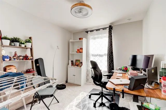 a view of a workspace with furniture and a window