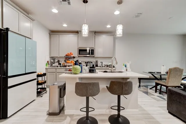 a kitchen with stainless steel appliances granite countertop a sink and a refrigerator