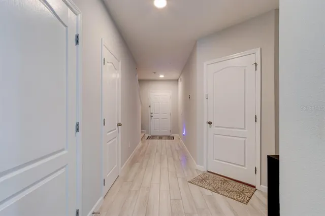 a view of a hallway with wooden floor and closet