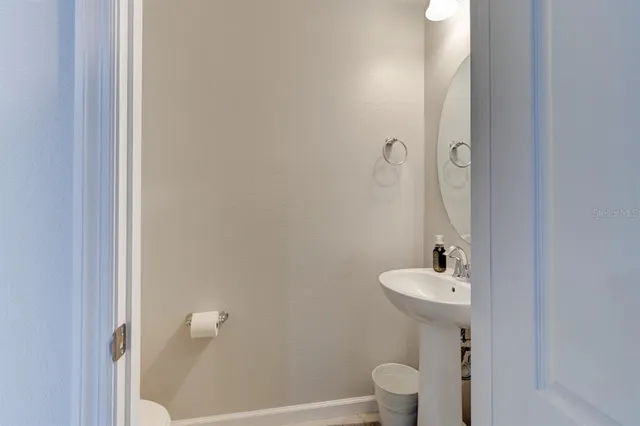 a bathroom with a sink toilet and a mirror