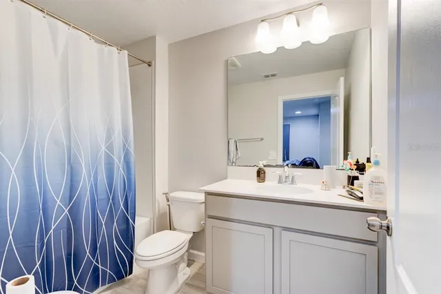 a bathroom with a sink a toilet and a mirror
