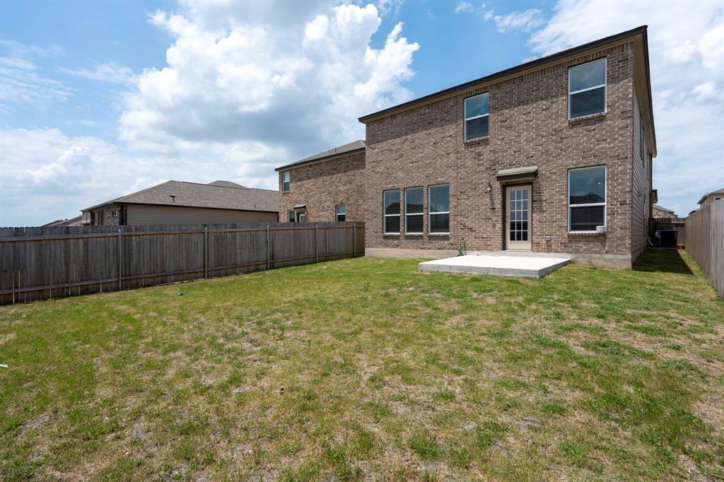 14100 Vigilance Street Manor, TX 78653 - Photo 28 of 32 a view of a backyard with table and chairs and wooden fence