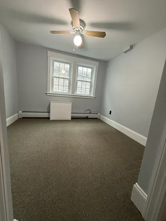 an empty room with windows and fan