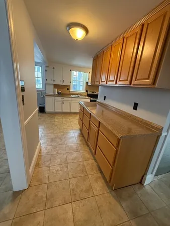 a kitchen with a sink a stove top oven and cabinetry