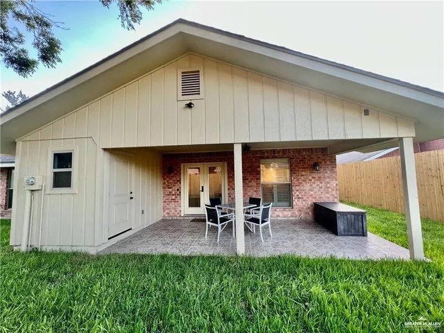 a front view of a house with porch and chairs