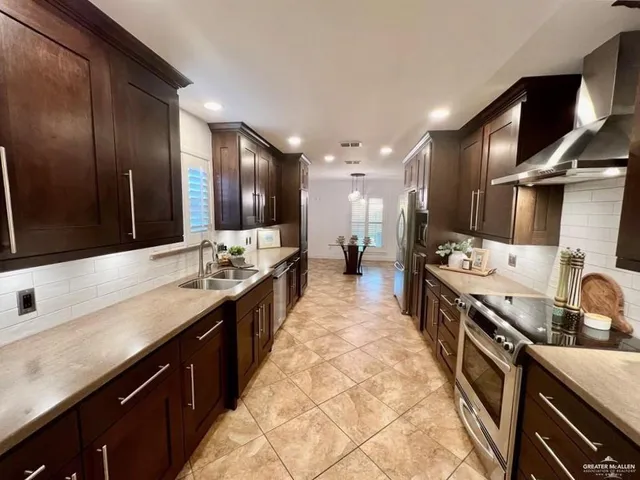 a large kitchen with stainless steel appliances double vanity and a sink