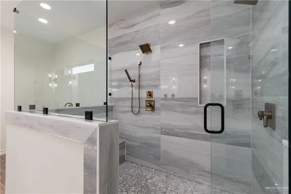 a bathroom with a granite countertop shower a sink and has a mirror
