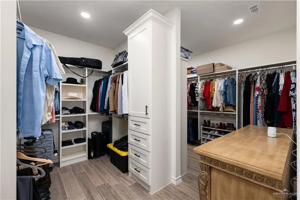 a view of walk in closet with clothes and shoes