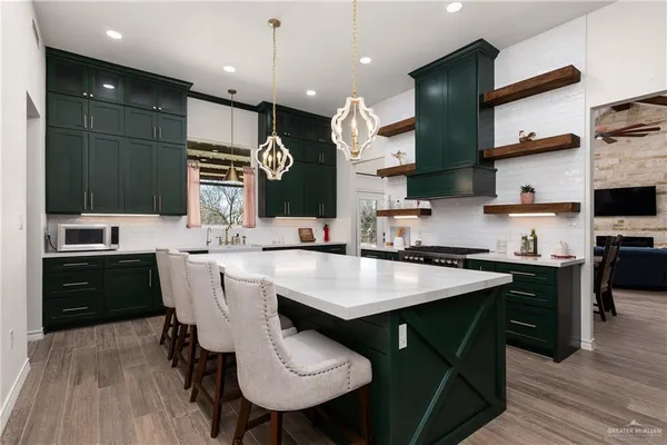 a kitchen with stainless steel appliances granite countertop a sink a stove and a refrigerator