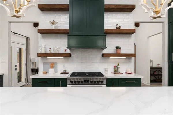 a kitchen with stainless steel appliances granite countertop a refrigerator and a stove