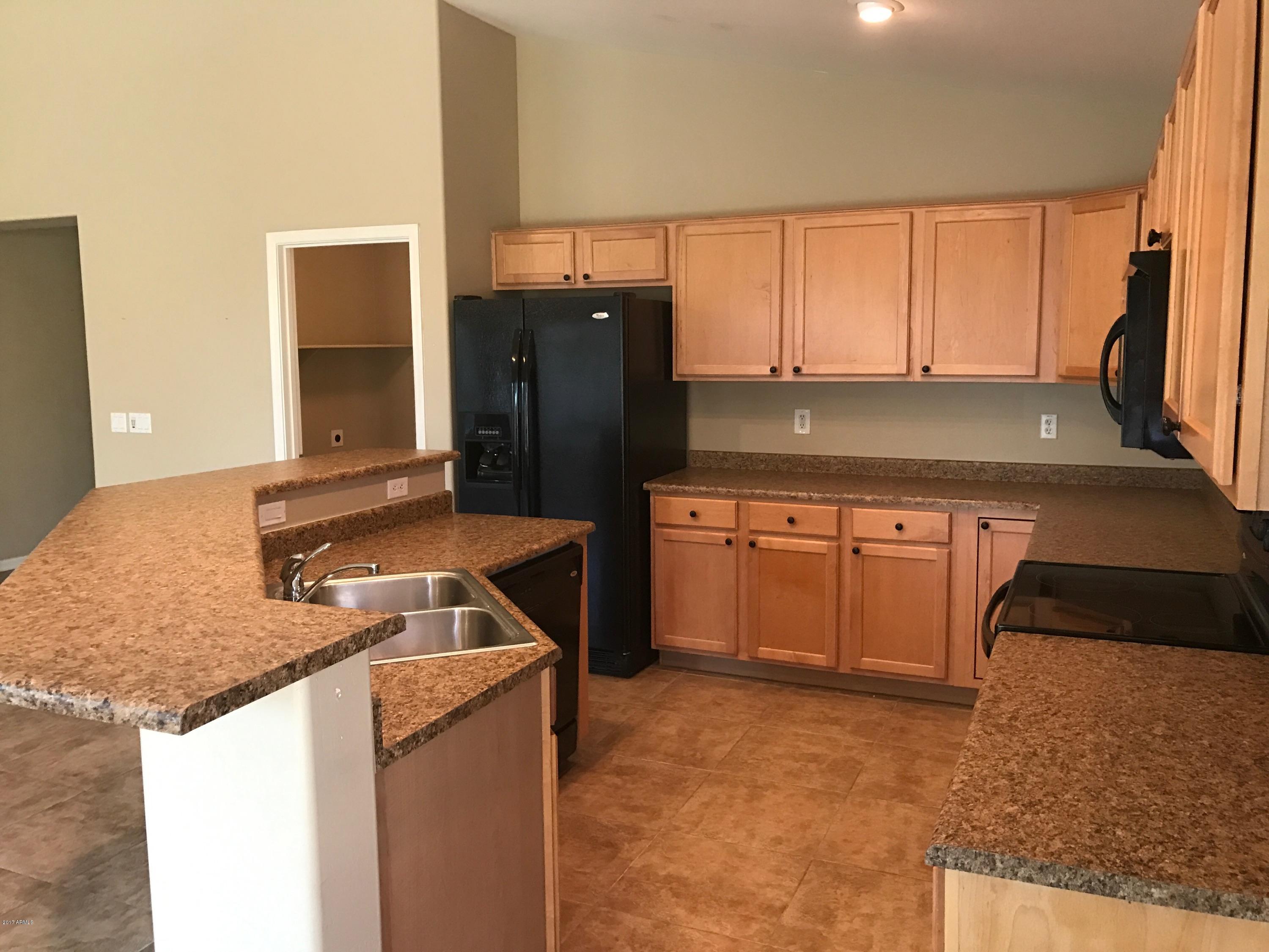 25655 West Ripple Road Buckeye, AZ 85326 - Photo 3 of 29 a kitchen with a sink stove and refrigerator