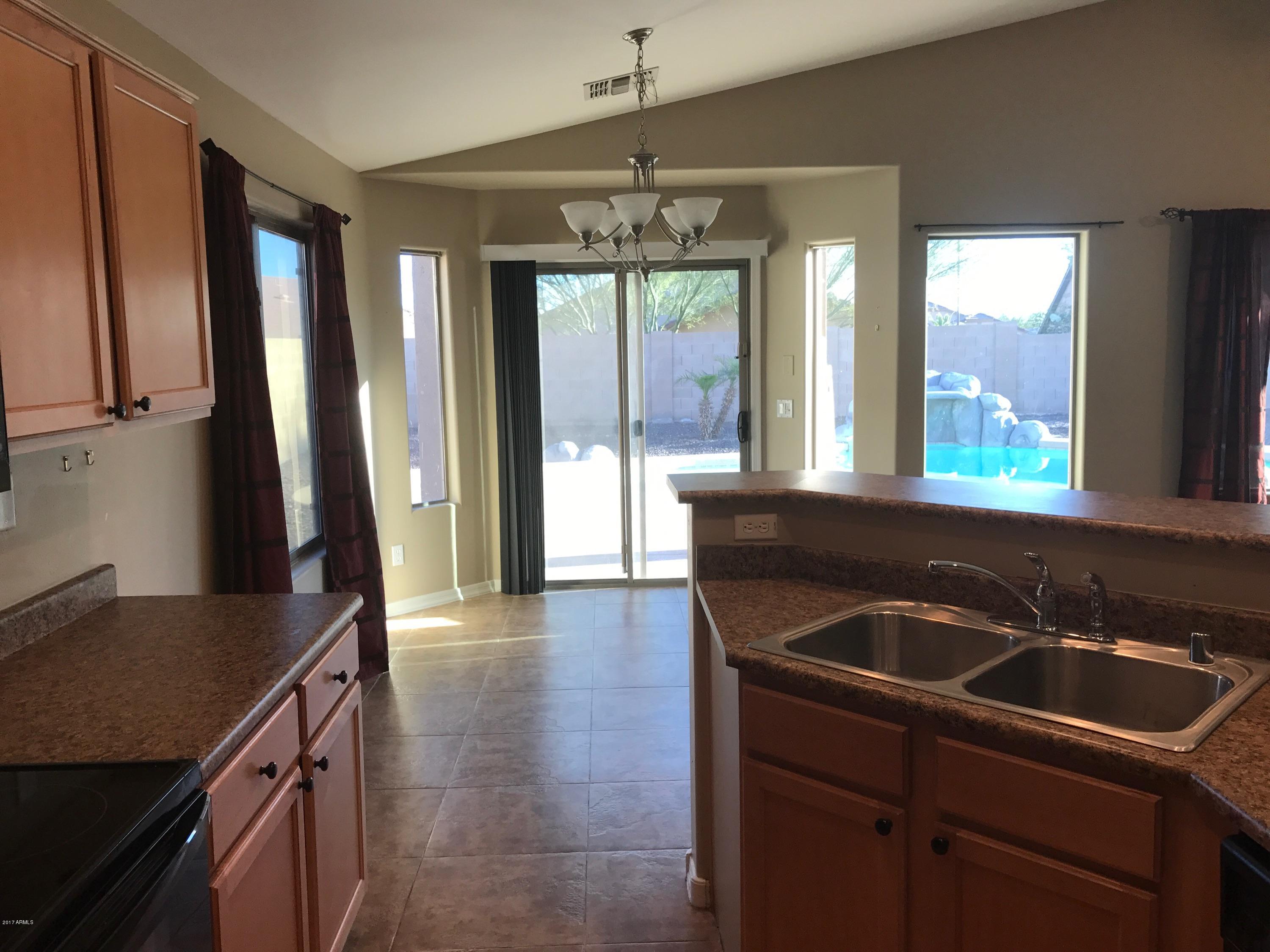 25655 West Ripple Road Buckeye, AZ 85326 - Photo 5 of 29 a kitchen with a sink a large window and stainless steel appliances