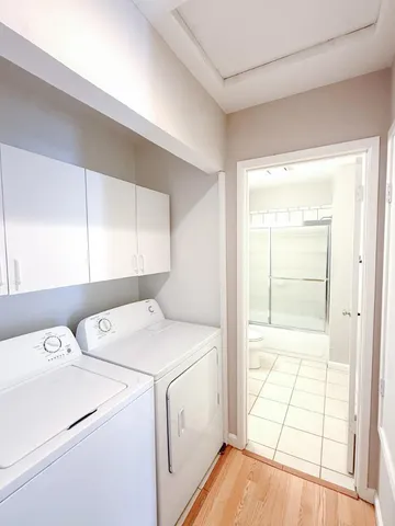 a view of washer and dryer with bathroom in the background