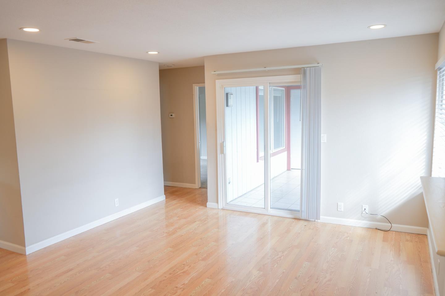 84 Rancho Drive, Unit H San Jose, CA 95111 - Photo 4 of 16 an empty room with wooden floor and windows