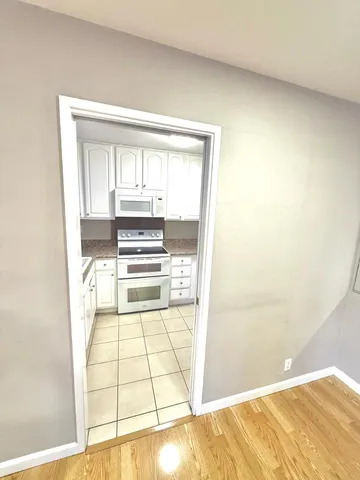 a view of a kitchen with wooden floor and a kitchen space