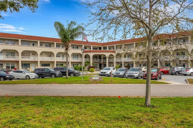 a view of multiple house with a big yard and large trees