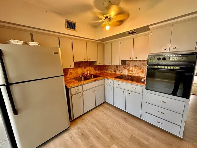 a kitchen with stainless steel appliances a refrigerator sink and cabinets