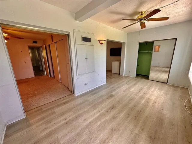 a view of a livingroom with wooden floor and a ceiling fan