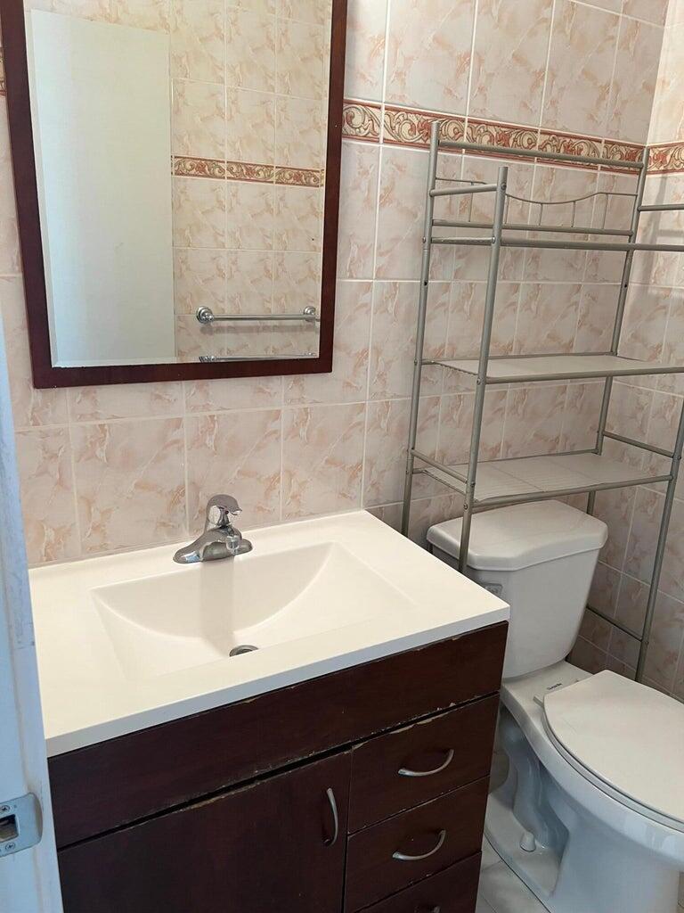 371 Flanders South, Unit 371 Delray Beach, FL 33484 - Photo 11 of 17 a bathroom with a sink a toilet and mirror