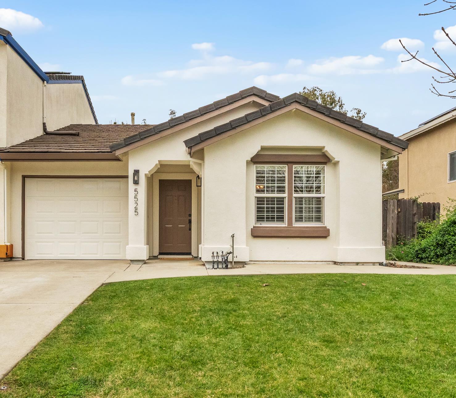 a front view of a house with a garden and yard