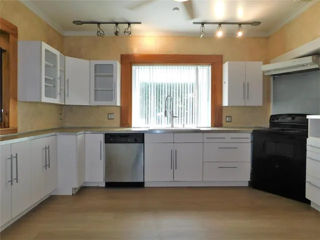 a kitchen with granite countertop white cabinets and black stainless steel appliances