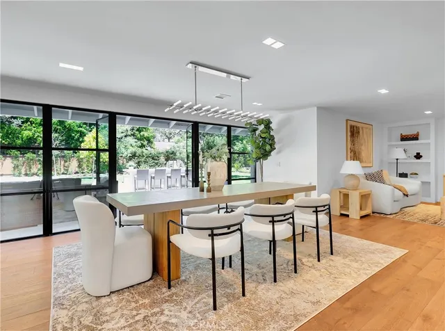 a kitchen with stainless steel appliances granite countertop a table and chairs in it