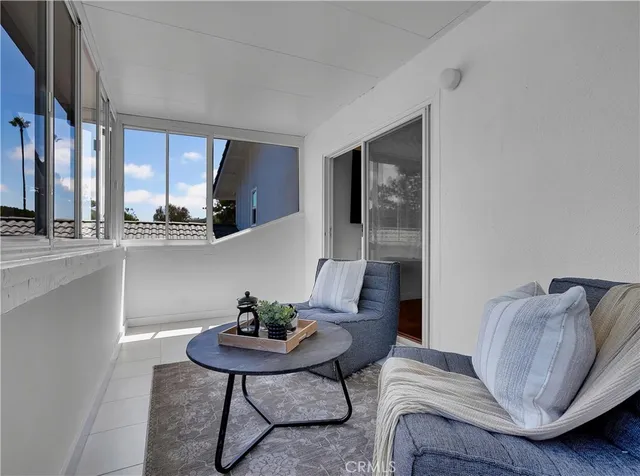 a living room with patio furniture and a garden