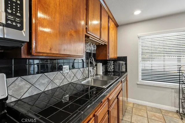 a kitchen with granite countertop a stove a sink and a microwave