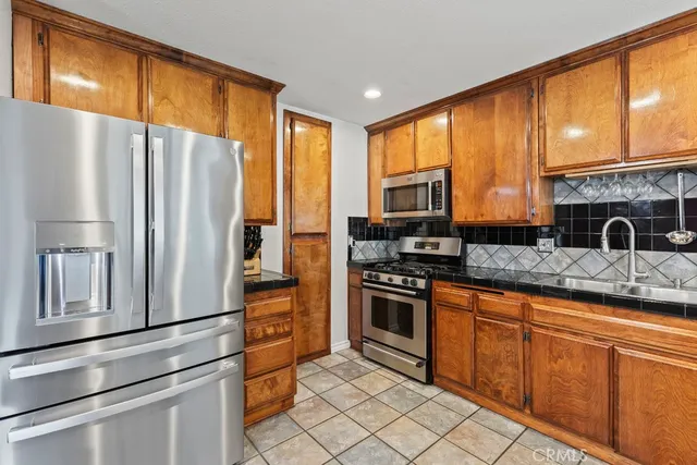 a kitchen with stainless steel appliances granite countertop a refrigerator a stove sink and cabinets