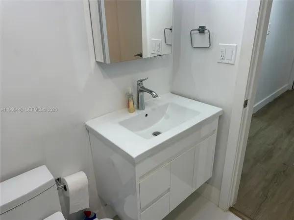 a bathroom with a sink a toilet and mirror