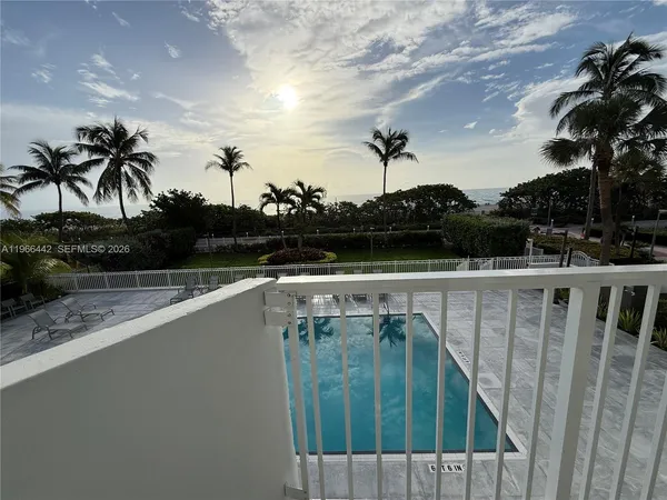 a view of swimming pool with lake and trees in the background