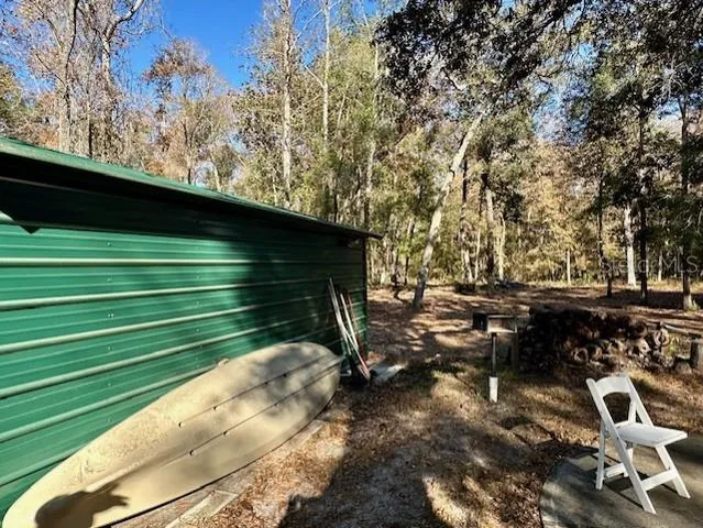 a view of backyard with wooden fence and a large tree