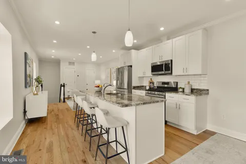 a kitchen with stainless steel appliances kitchen island granite countertop a sink and cabinets